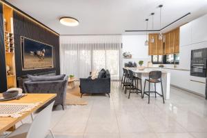 a kitchen and living room with a table and chairs at אחוזת אבישג - וילה יוקרתית עם בריכה מחוממת וממ"ד למשפחות in Shelomi