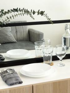 a table with white plates and glasses on it at Casa De Baguio in Town Center in Baguio +32 photos