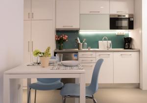 a kitchen with a table and two blue chairs at Homz Studios Faliro in Athens