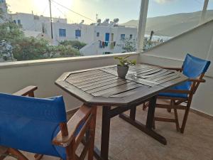 a wooden table and two chairs on a balcony at Aegeon Pension in Aegiali