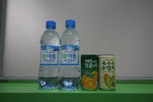 two bottles of water and a can on a green shelf at 에스모텔 in Ch'ŏngnyong-dong