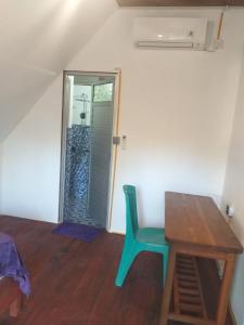 a room with a table and a green chair in front of a door at Surf Logde katiet short motorcycle only minute from our places Bintang wave,Lance wave,HTs wave,monkeyWave in Katiet