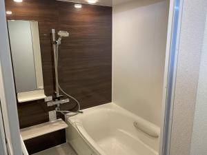 a bathroom with a bath tub with a shower at 民宿一休 in Otaru +8 photos