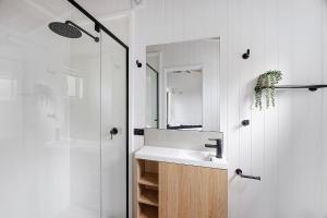 a white bathroom with a sink and a shower at Reflections Evans Head - Holiday Park in Evans Head +141 photos