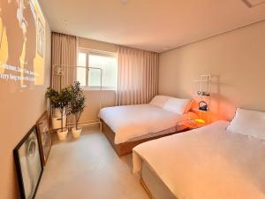 a hotel room with two beds and a window at Stay BUT SEONGSU in Seoul