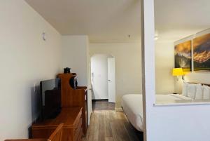 a room with a bed and a television and a bedroom at Days Inn by Wyndham Bishop in Bishop