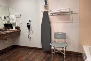 a bathroom with a chair and a phone on the wall at Days Inn by Wyndham Bishop in Bishop +39 photos