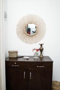 a mirror on a white wall above a wooden dresser at Ocean Life Ayurvedic Villa in Talalla South +101 photos