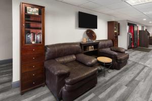 a waiting room with a leather couch and a tv at Days Inn by Wyndham Pierre in Pierre