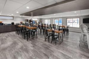 a restaurant with wooden tables and chairs in a room at Days Inn by Wyndham Pierre in Pierre