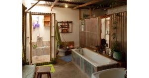 a bathroom with a bath tub and a toilet at Oloile - Home By The Park in Nairobi +63 photos