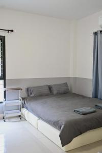 a bed in a room with a white floor at บ้านอิงฟ้าแม่ฮ่องสอน in Ban Mai Ngae