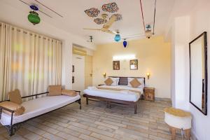 a bedroom with two beds and a couch at Dreamyard Udaipur in Udaipur +82 photos
