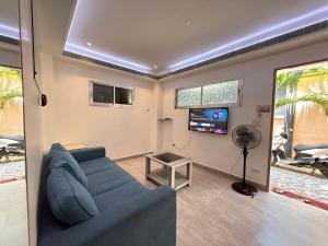 a living room with a blue couch and a flat screen tv at Logan Apartments in Bantayan Island