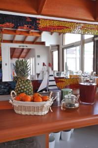 a counter with a basket of oranges and a pineapple at Kai Bed and Breakfast in Algarrobo