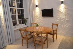 einen Holztisch mit Stühlen und einen TV an der Wand in der Unterkunft Apartment Into3City Old Town Gdansk in Danzig