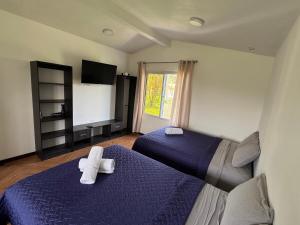 a bedroom with two beds and a flat screen tv at Casa Escondida in San Felipe