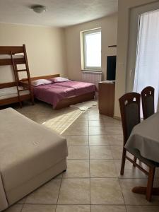 a bedroom with two beds and a table and chairs at Tourist Farm Robivera in Šmarje