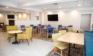 a waiting room with tables and chairs and a tv at Hampton Inn Shrewsbury in Shrewsbury