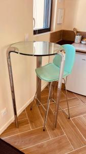 a glass table and a green chair in a kitchen at Suite Master in Brest