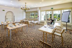 a classroom with tables and chairs in a room with windows at Sure Hotel by Best Western Rhoen Garden in Poppenhausen +87 photos