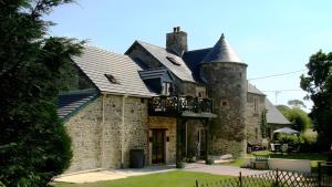 an old stone house with a balcony on it at Grange Cottage - La Mare Chappey in Néhou