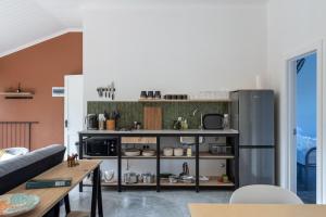 a living room with a kitchen with a refrigerator at Cape Dutch Stay, Suite B in Sedgefield +24 photos