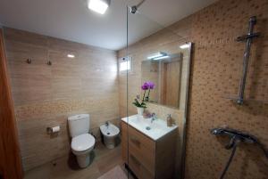 a bathroom with a toilet and a sink and a shower at Estrela do Mar - Alojamento Local in Calheta +4 photos