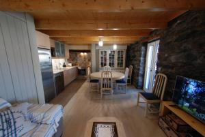 a kitchen and living room with a table and chairs at Estrela do Mar - Alojamento Local in Calheta