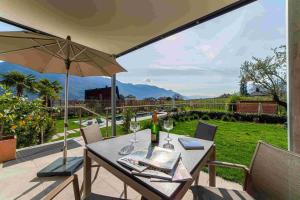 a table with wine glasses and an umbrella on a patio at Haus Wiesenstein in Lana