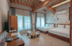 a bedroom with two beds and a desk and a television at Jeonju Wangyijimil Hanok Hotel in Jeonju