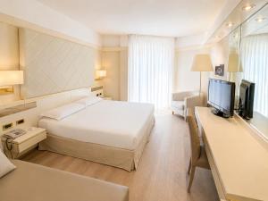 a hotel room with a bed and a flat screen tv at Hotel Bristol in Sottomarina