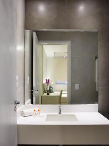 y baño con lavabo blanco y espejo. en Injoy Lofts Ipanema, en Río de Janeiro