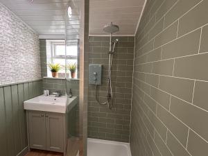 a bathroom with a sink and a shower at The Moorings, overlooking Loch Fyne in Cairndow +28 photos