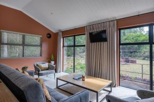 a living room with a couch and a table at Cape Dutch Stay, Suite B in Sedgefield