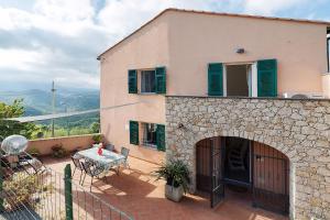 a house with a patio and a table on a balcony at Casa Vacanze Il Primo Sole in Finale Ligure