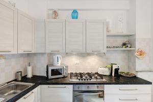 a kitchen with white cabinets and a stove top oven at Casa Vacanze Il Primo Sole in Finale Ligure