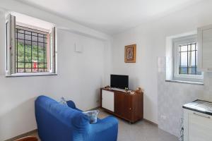 a living room with a blue couch and a television at Casa Vacanze Il Primo Sole in Finale Ligure
