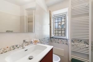 a bathroom with a sink and a toilet and a window at Casa Vacanze Il Primo Sole in Finale Ligure +14 photos