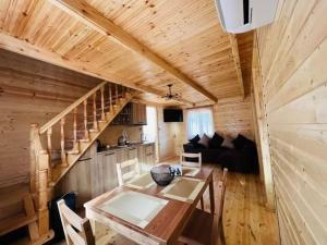 a dining room and living room with a wooden ceiling at Cliffside - ქლიფსაიდი in Makhunts'et'i