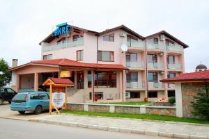 a building with a car parked in front of it at Hotel Akre in Kavarna