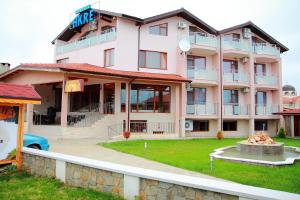 a large pink building with a fountain in front of it at Hotel Akre in Kavarna