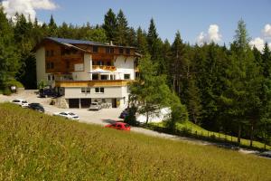 un grande edificio con auto parcheggiate in un parcheggio di Hotel Pension Tyrol a Seefeld in Tirol