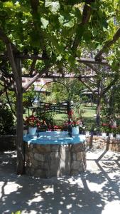 a table with flowers on it under a tree at Maniatis Garden in Achladies