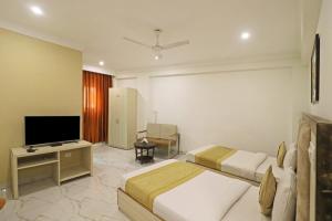 a hotel room with two beds and a flat screen tv at Hotel Stay Premium- Free Airport Tranffer in New Delhi
