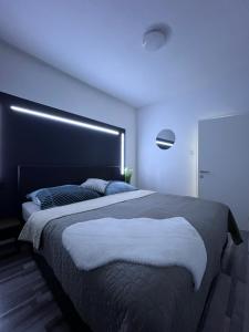 a bedroom with a large bed with a black headboard at Modernes City Apartment 8km Red Bull Ring in Knittelfeld