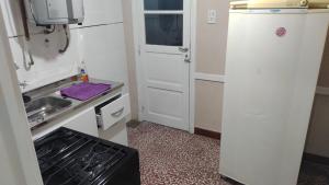 a small kitchen with a refrigerator and a sink at Edén in La Falda