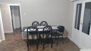 a dining room table with four chairs and a glass table at Edén in La Falda +9 photos