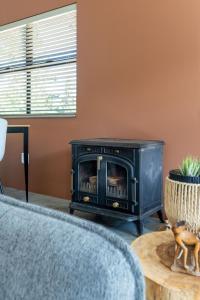 a fireplace in a living room with a stove at Cape Dutch Stay, Suite B in Sedgefield
