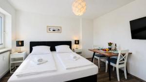 a small bedroom with a bed and a table at CBlue "Apartmenthaus Padua", zentral in Warnemünde